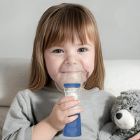 Niña usando el nebulizador con la mascarilla